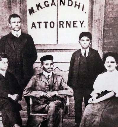 Mahatma Gandhi sitter med fyra medarbetare framför sitt advokatkontor i Johannesburg, Sydafrika, Sydafrika av Unknown photographer