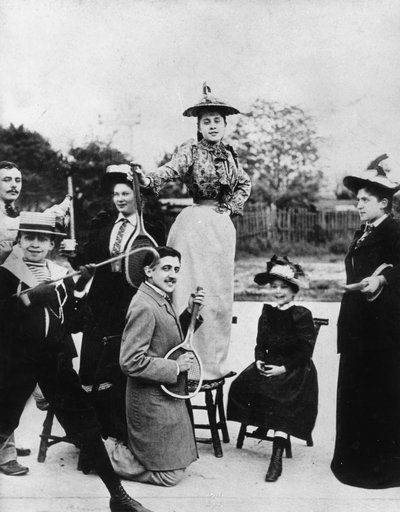 Marcel Proust (1871-1922) knäböjer med en tennisracket framför Jeanne Ponquet stående på en stol i Neuilly (Frankrike) 1892 av Unknown photographer