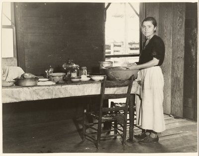 [Elizabeth Tengle vid köksbordet]/[Paralee Ricketts arbetar i köket] av Walker Evans