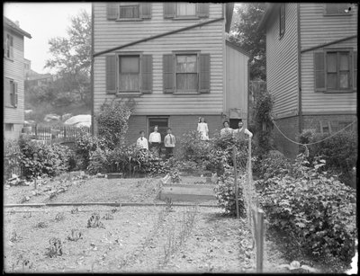 Familjen poserar bredvid sin grönsaksträdgård på bakgården, Inwood, New York, ca 1910 av William Davis Hassler