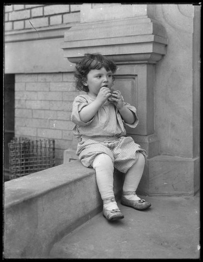Småbarnet "Duffy" på framsidan av lägenhetsbyggnaden Vermilyea Avenue, New York, ca 1913 av William Davis Hassler