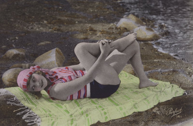 Flicka som ligger på handduken på stranden (färgat foto) av English Photographer