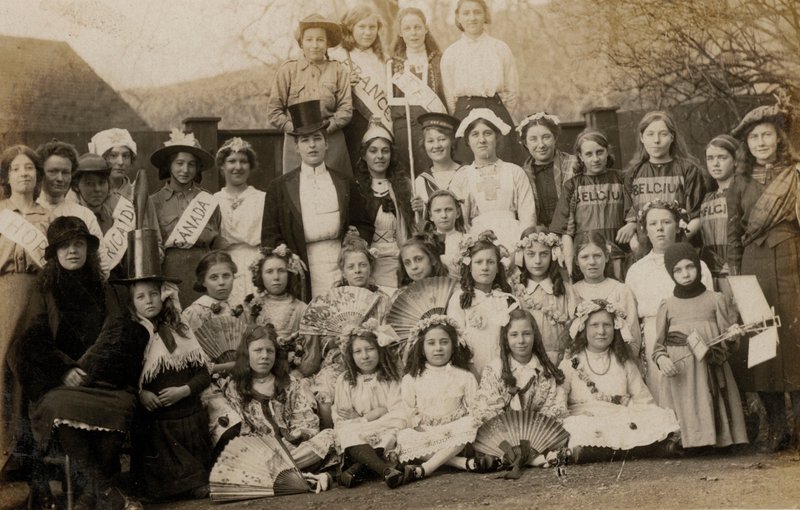 Porträtt av en grupp skolflickor med sina lärare klädda i världens kostymer (s/v foto) av English Photographer