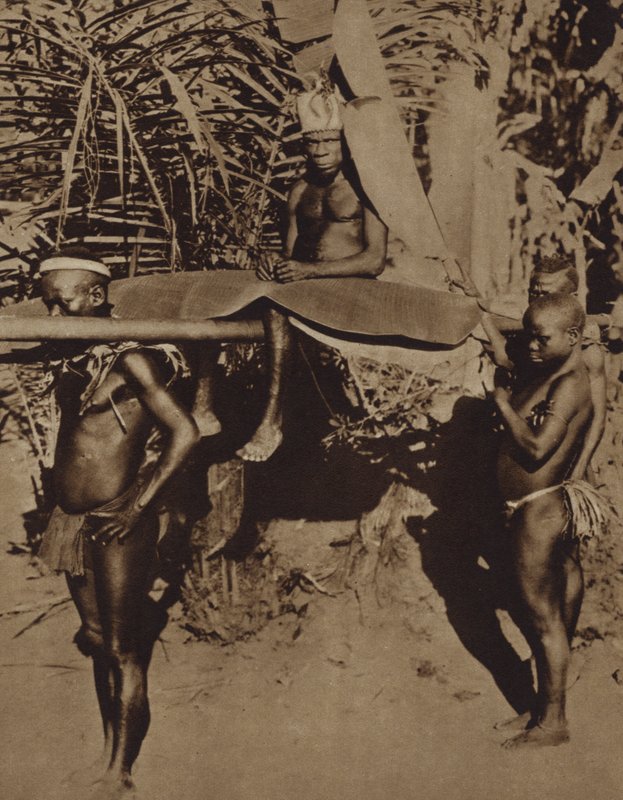 Chef för en afrikansk pygmé-stam som bärs på en kull (s/v foto) av European Photographer