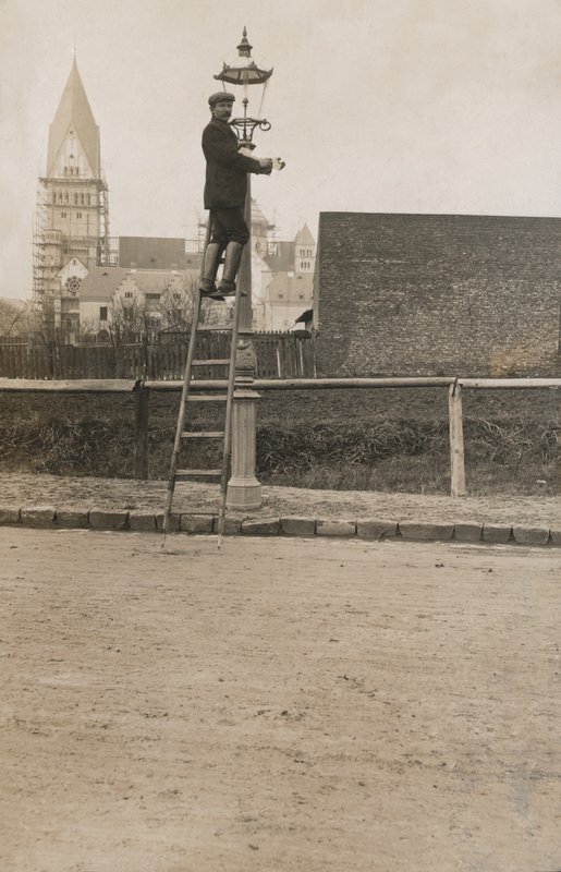 Man uppför en stege och fixar en gatlykta (s/v foto) av European Photographer