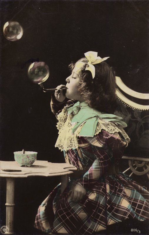 En liten flicka som blåser bubblor från ett rör (tonat foto) av French Photographer