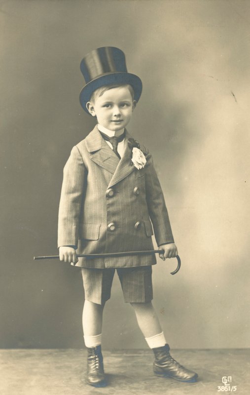 Pojke i dubbelknäppt kostym, klädd i hatt och håller en käpp av French Photographer