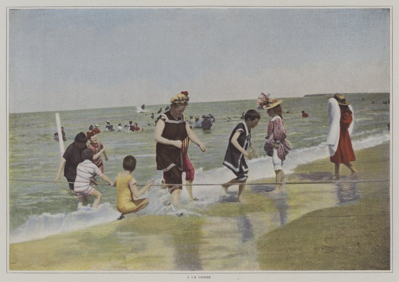 Barn som leker med ett rep på stranden (färgfoto) av French Photographer