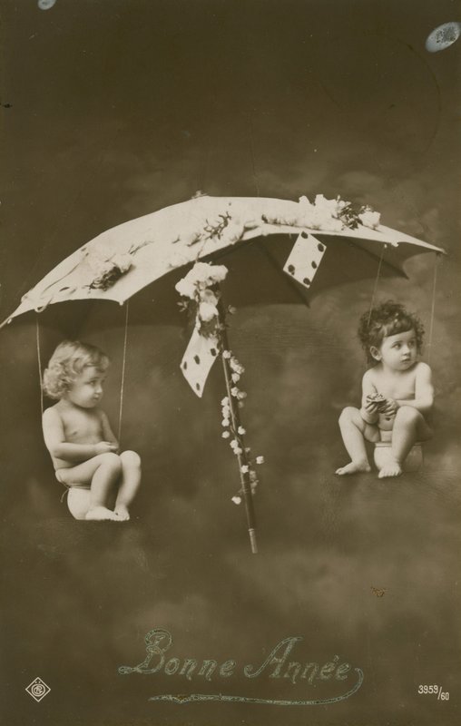 Gott nytt årskort med två bebisar hängande i ett paraply, skickat 1913 av French Photographer