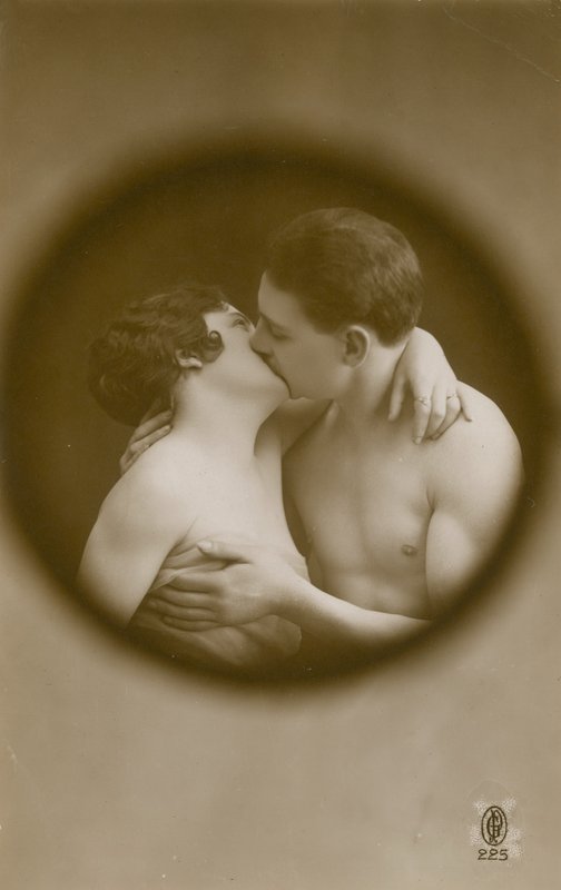 Vykort av en ung man och kvinna som kysser sett genom ett titthål, skickat 1913 av French Photographer