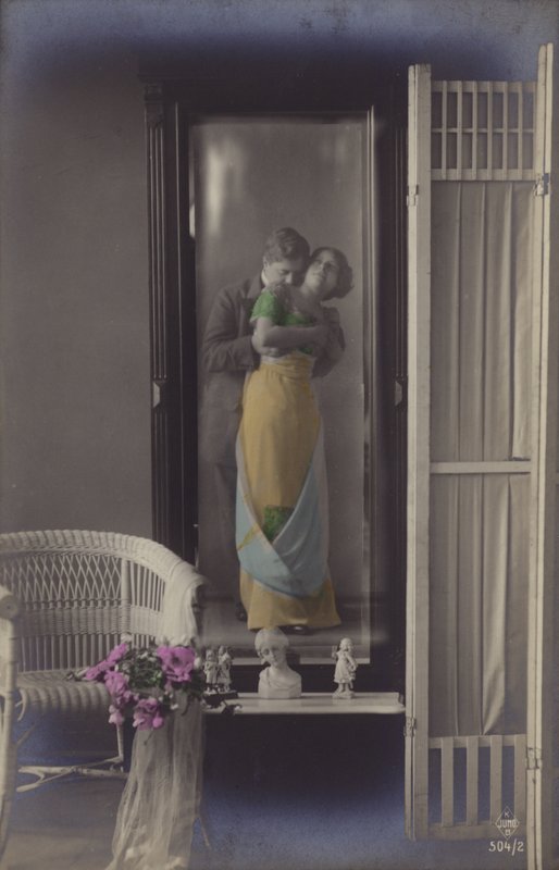 Reflexionen i en spegel av ett ungt par som kysser (tonat foto) av French Photographer