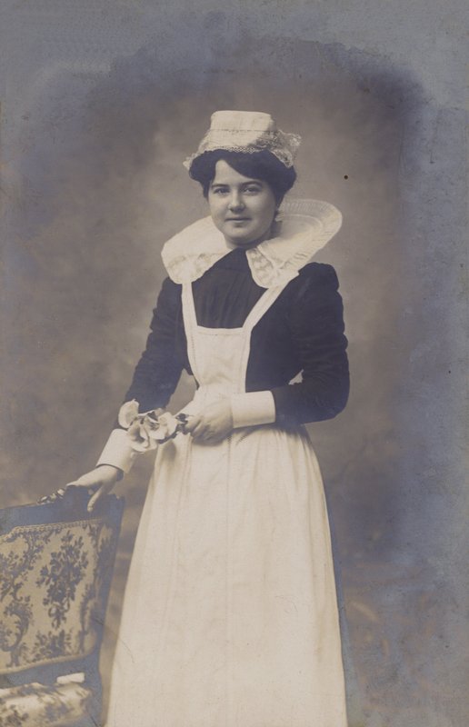 Ung flicka, hembiträde (?), håller i ett litet knippe blommor av French Photographer