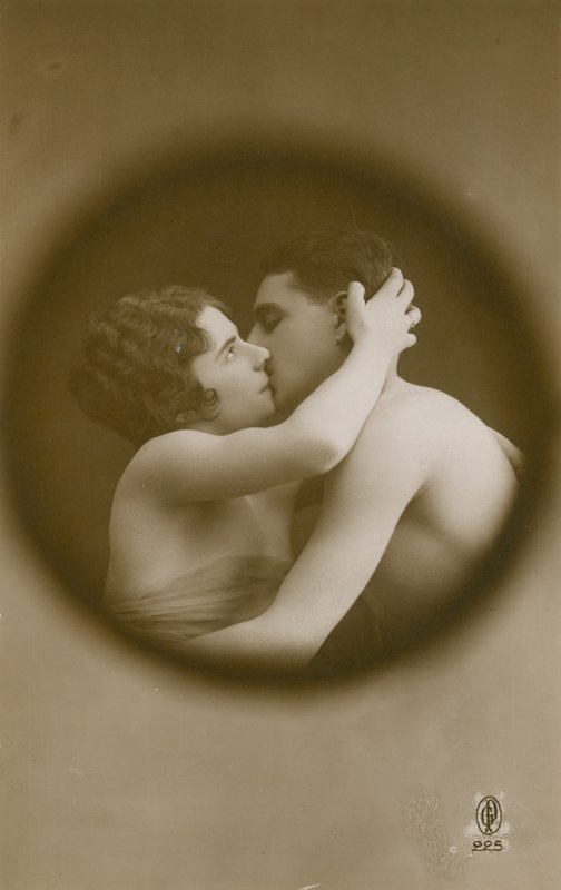 Ung man och kvinna kysser sett genom ett titthål. Vykort skickat 1913. av French Photographer