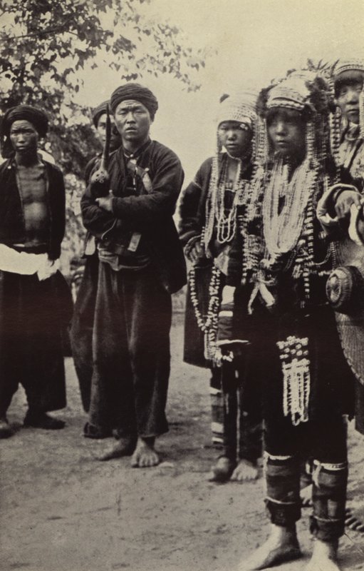 Burma: Akha-män med kvinnor i all sin prakt (s/v-bild) av Georges Bertin Scott