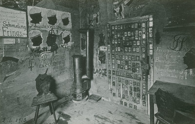 Ett rum med väggar täckta av graffiti som refererar till viktiga samtida personer som Bussche och Waldow. Vykort skickat 1913. av German Photographer