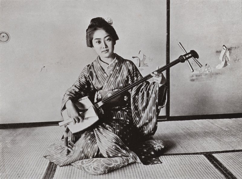 En geisha som spelar samisen (s/v foto) av Herbert Ponting