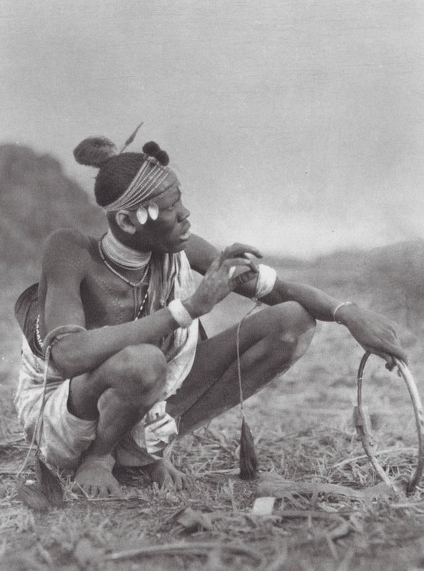 Afrika: Dinka-brudgummen köpslår om brudprydnaderna (svartvitt foto) av Hugo Adolf Bernatzik