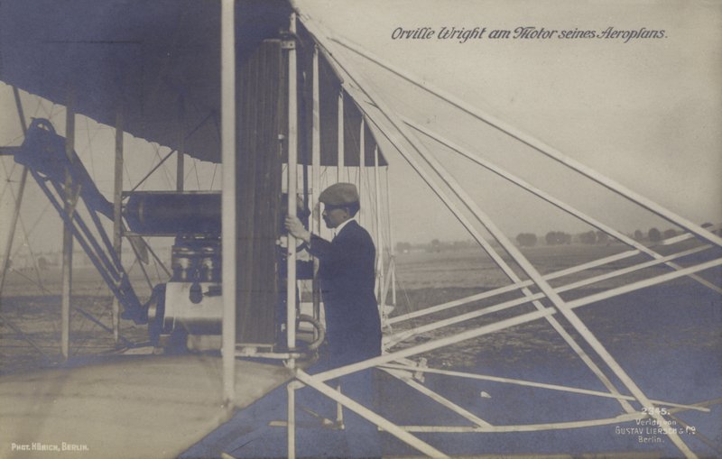 Amerikanska flygaren Orville Wright inspekterar motorn på sitt flygplan (s/v foto) av Photographer German