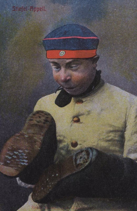 Tysk soldat tittar på sulorna på sina stövlar (färgat foto) av Photographer German