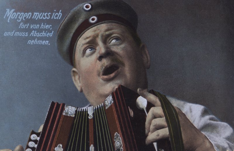Tysk soldat spelar ett dragspel (färgat foto) av Photographer German