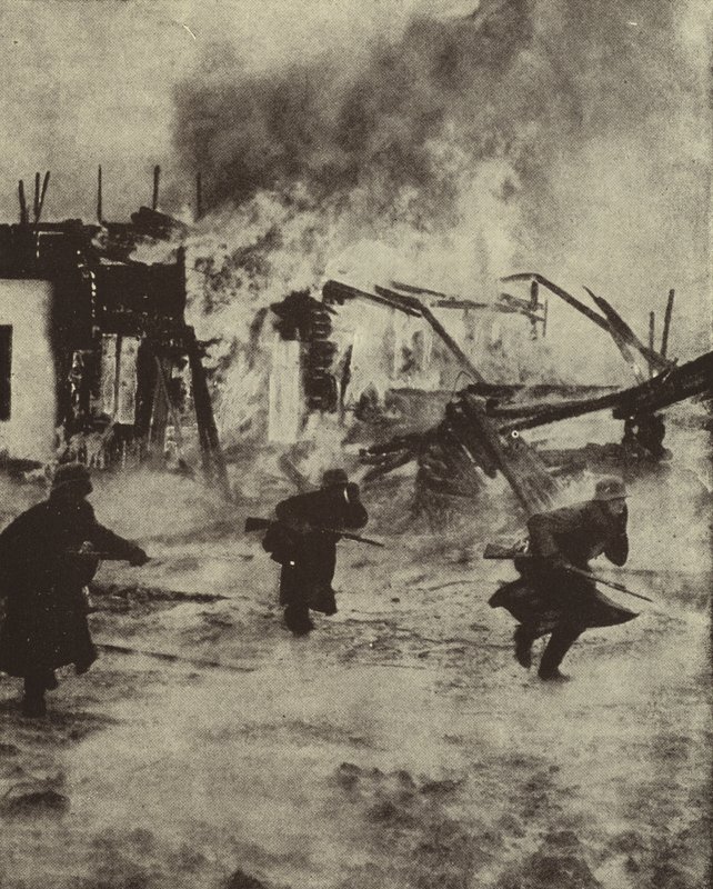 Tyska soldater som rycker fram genom de brinnande ruinerna av Rotterdam efter dess bombning av Luftwaffe, andra världskriget, maj 1940 (s/v foto) av Photographer German