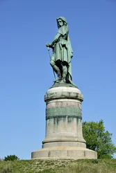 Kolossalstaty av Vercingetorix (72-46 f.Kr.), gallisk ledare. Skulptur av Aimé Millet (1819-1891), 6,60 m hög, rest 1865 på den västra delen av Mont Auxois, med en 7 m hög sockel av Viollet-le-Duc. Alise-Sainte-Reine, 1865