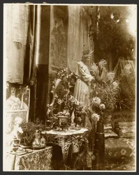 [Ett hörn av Muchas ateljé med statyer, grafik och blommor, Rue du Val-de-Grâce, Paris]