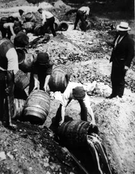 En amerikansk federal agent övervakar förstörelsen av ölfat under den amerikanska förbudstiden (1920-33) (s/v foto)