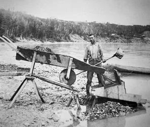 En prospektör som laddar en "rocker" eller "vagga" för att tvätta guld från Klondike-flodens vatten under Klondike Gold Rush (1897-98) 1898 (s/v foto)