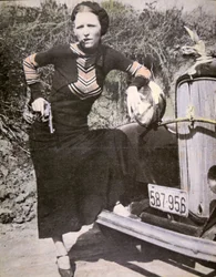 Bonnie Parker poserar „tufft“ med en pistol och en cigarr, ca 1934