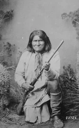 Geronimo håller ett gevär, 1884