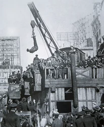 Houdini flyr från en tvångströja medan han hängde i en kran i New York City (s/v foto)