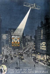 Alkoholreklam "" White Rock"": Ett plan som lyser upp "White Rock"-affischen som hänger på en byggnad på Times Square i New York. 1912.