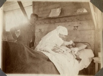 Första världskriget 1914-1918: sjuksköterska i blus rakar en soldat (franska krigssår ligger i en säng), i Couville, Manche, Basse-Normandie (Lagre Normandie), Frankrike. Anonymt fotografi juli 1917. Privat samling, Stella.