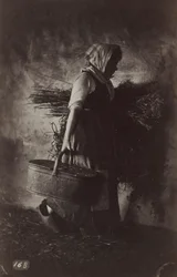 Kvinnlig bonde som bär en korg och hö, ca. 1870.