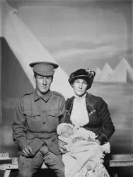 Studioporträtt av 1159 privat (Pte) George Beamish Swanton, australiensiska 24:e bataljonen, från Werribee, Victoria, med sin fru Nellie och sin lilla baby, Joan Helen, ca. maj 1915