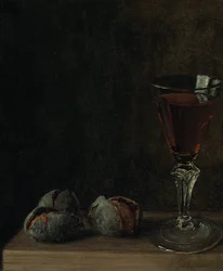 Ett glas vin med valnötter på ett bord
