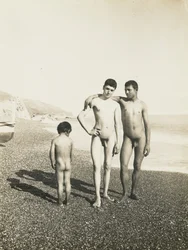 Två unga män och en pojke på stranden