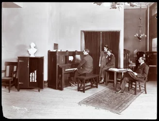 Fyra män, varav en spelar ett piano från H. Bruman Co., 1907 (silvergelatintryck)