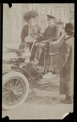 Hattie Williams sittande med förare i en av New York Citys första bilar, New York, 1890-1910 (silvergelatintryck)