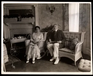 Porträtt av Mr. och Mrs. Howard sittande poserade i ett vardagsrum i deras hem på 200 5th Avenue, New York, 1916-6 (silvergelatintryck)