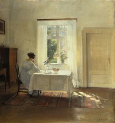 En kvinna sittande vid ett bord intill ett fönster, ca 1900