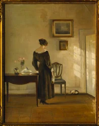 En interiör med en kvinna som matar en katt (olja på duk)