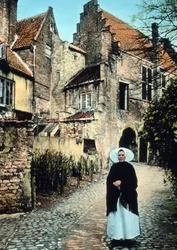 Nederländerna, provinsen Zeeland. Kvinna framför Kuipers-portalen i staden Middelburg. Bilddatum: cirka 1920. Carl Simon-arkivet