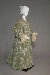 Bertha Palmers aftonrock, ca 1902 (snett framifrån). Sidensatäng med skuren sammet i vetemönster, metalltrådspets, silkesmetallic tofsar. Värt, Paris.