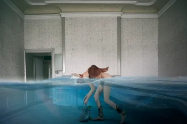 Surrealistisk kvinna i ett översvämmat rum