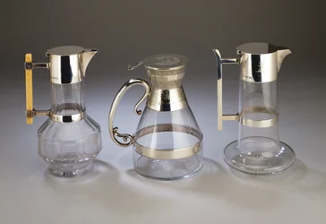 Silvermonterad claretkanna, 1882; elektroplåtmonterad claretkanna med dekor i estetisk stil till fästen; silvermonterad claretkanna, 1880, allt tillverkat av Hukin & Heath (slipat glas)