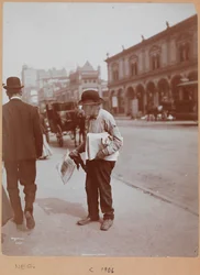 En mand, der står på fortovet i Broadway mellem 34th St. og 35th St. og holder The Evening Telegram avis