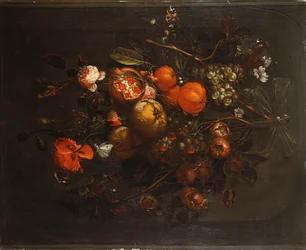 En bukett med frukt och blommor som hänger från en spik i en nisch