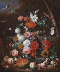 Stilleben med blommor och frukt på en stenplint i en trädgård